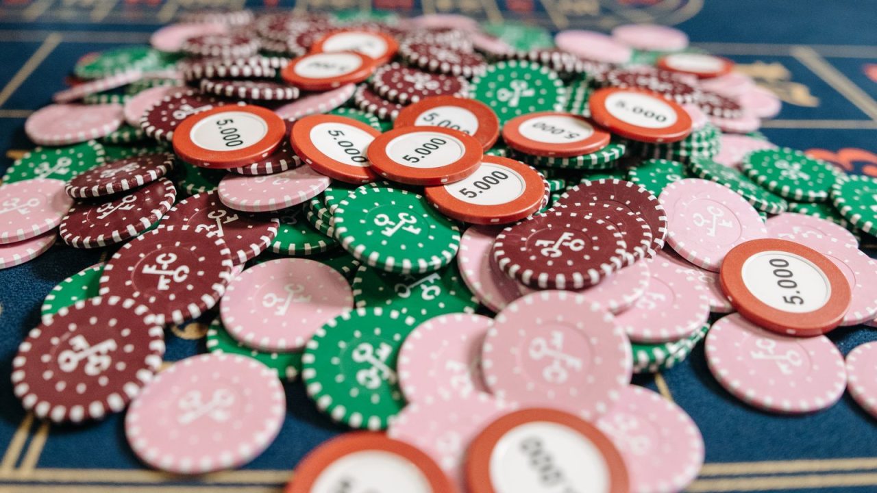 A colorful pile of poker chips on a casino table in a close-up view, emphasizing gambling concepts.