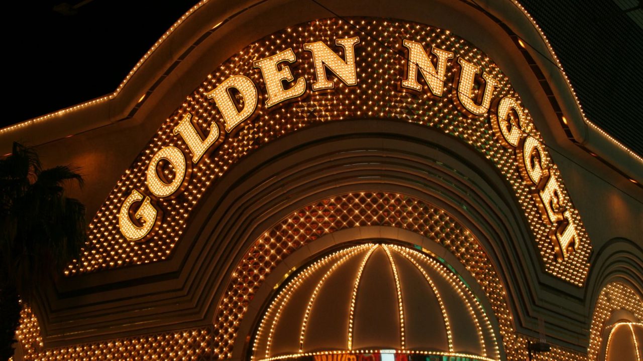 Iconic Golden Nugget casino entrance with bright lights at night in Las Vegas.